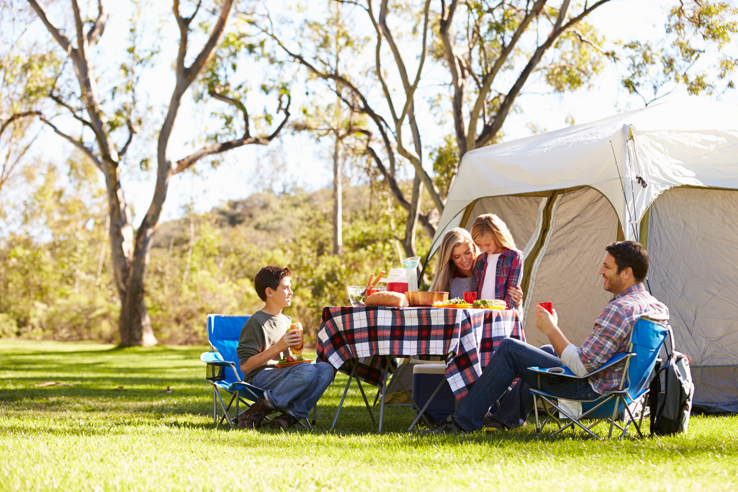 Family Enjoying Camping Holiday In Countryside