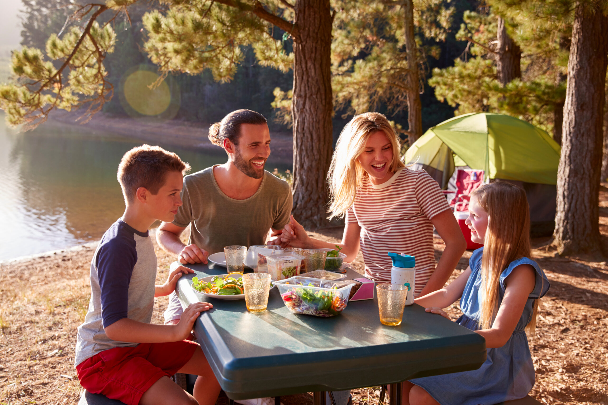 Family Camping By Lake On Hiking Adventure In Forest